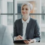 Woman in suit interviews man across table